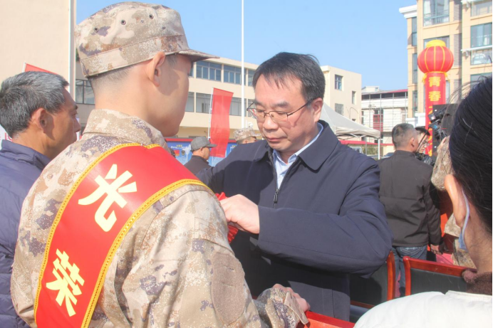 繁昌區(qū)委書記汪敏為出征新兵佩戴大紅花167.png
